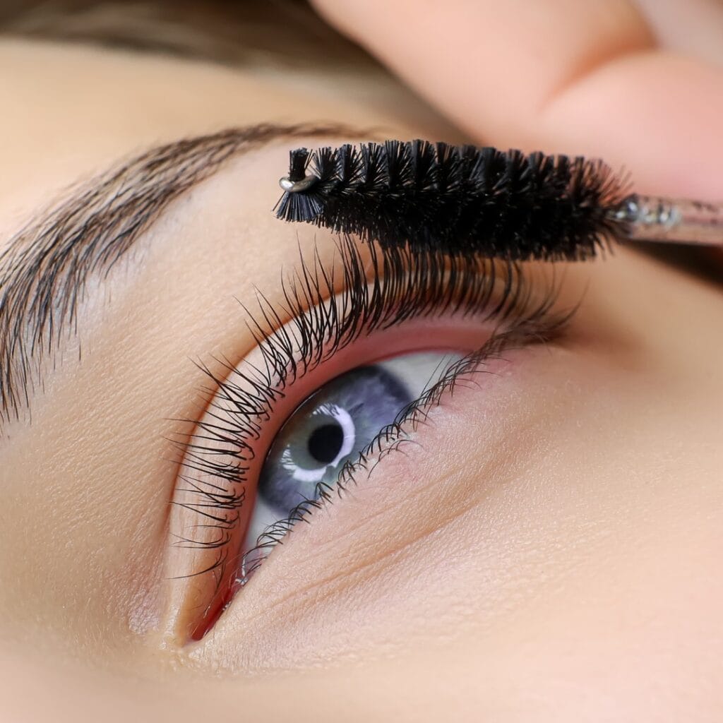 Female client receiving lash service at Fabulously Beautiful in Sutton Valence. We offer brow wax, tint & pmu services, lash lifts and lash tints. Image depicts a lash wand being used to brush through client's lashes.