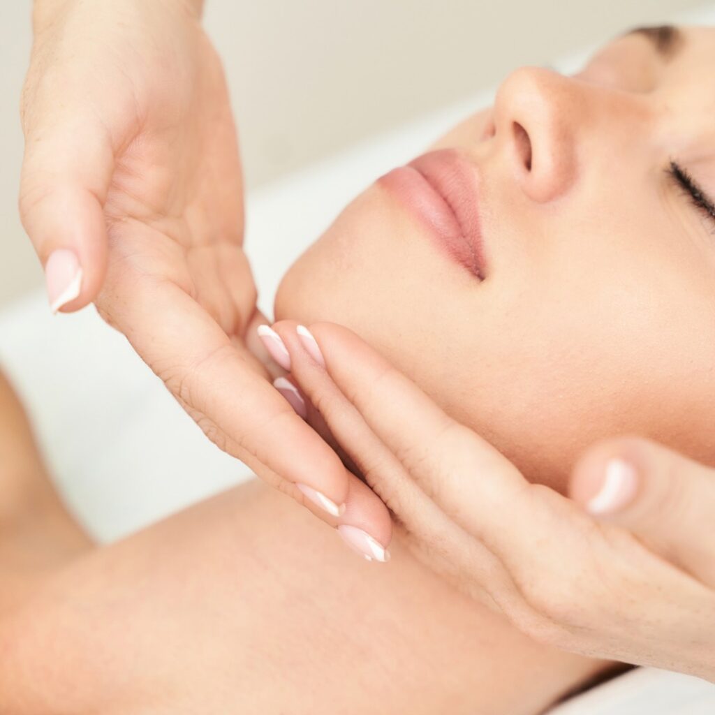 Fabulously Beautiful Kent, Amy Burbridge Home Salon. Female client receiving a facial massage. Therapist hands cup client chin on