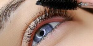 Female client receiving lash service at Fabulously Beautiful in Sutton Valence. We offer brow wax, tint & pmu services, lash lifts and lash tints. Image depicts a lash wand being used to brush through client's lashes.