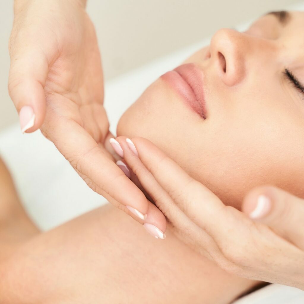 Fabulously Beautiful Kent, Amy Burbridge Home Salon. Female client receiving a facial massage. Therapist hands cup client chin on